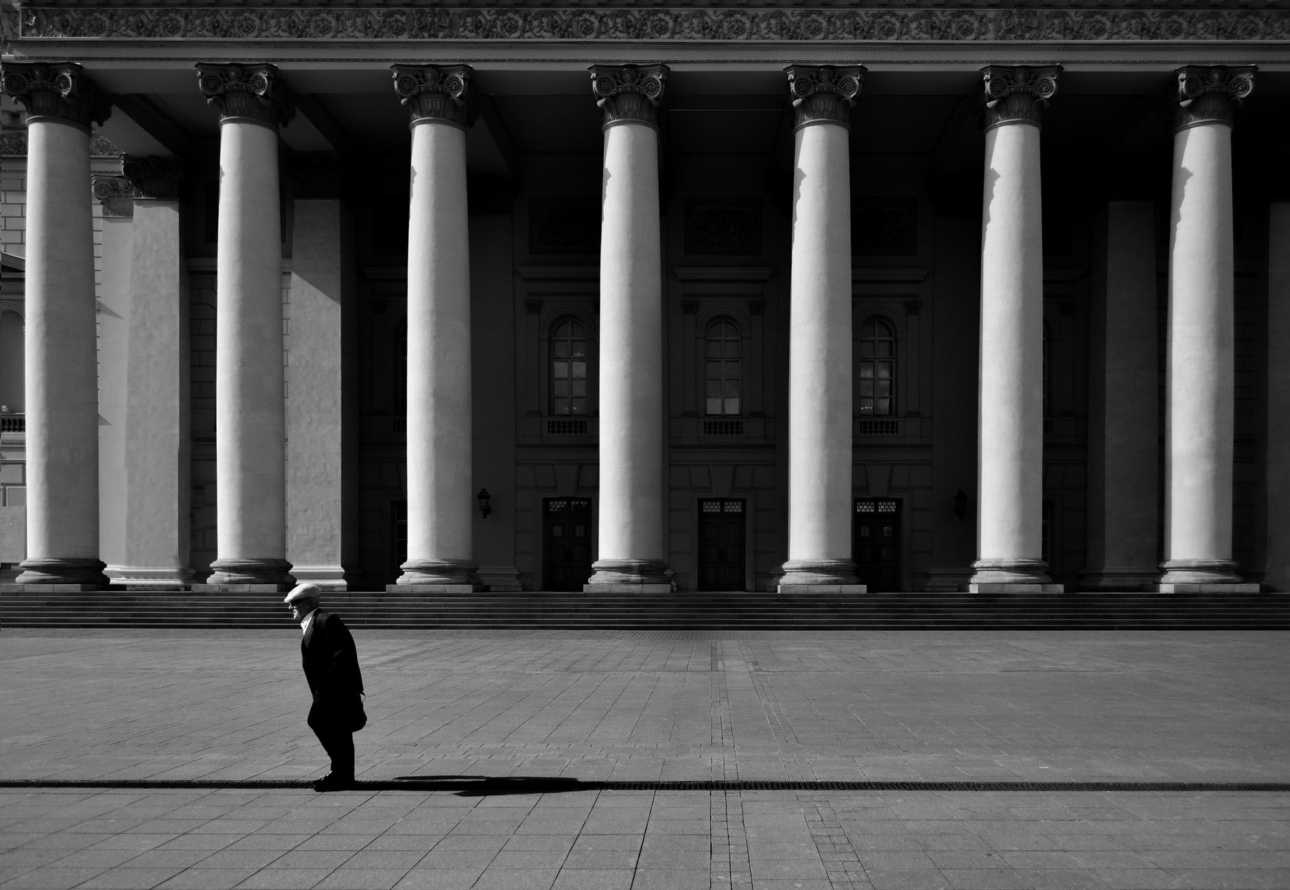 unrecognizable citizen against old urban building with colonnade